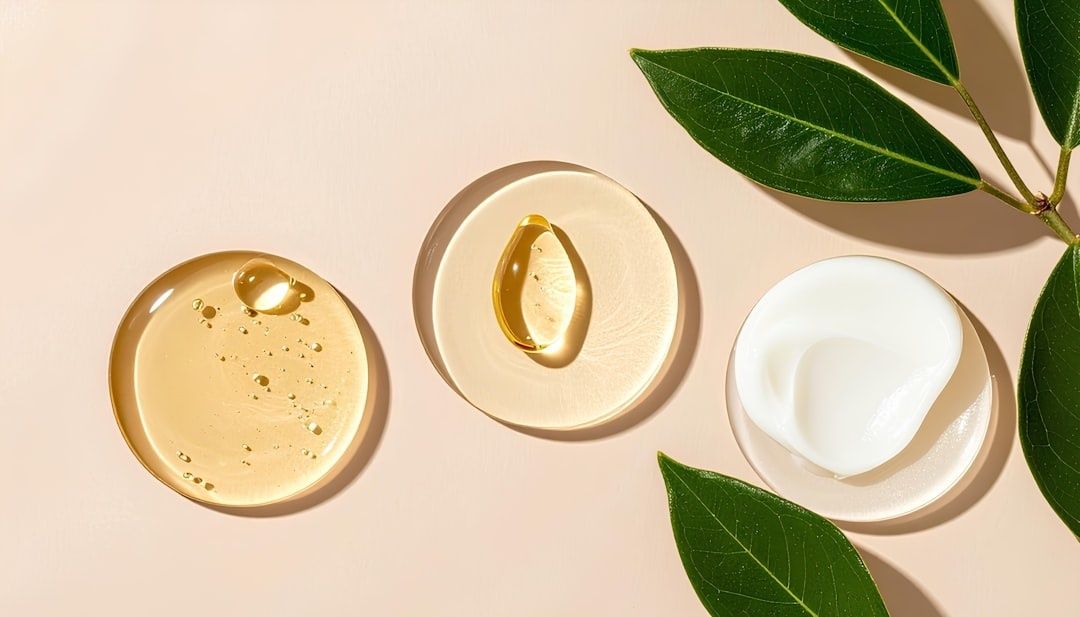 Droppar av gyllene serum och vit kräm med gröna blad