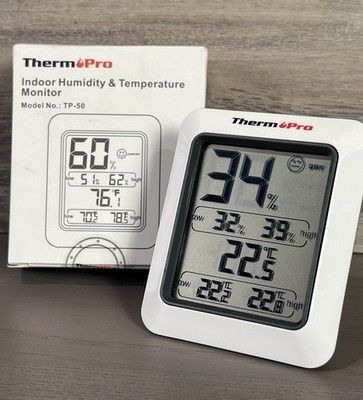 Digital hygrometer som visar temperatur och luftfuktighet på ett bord